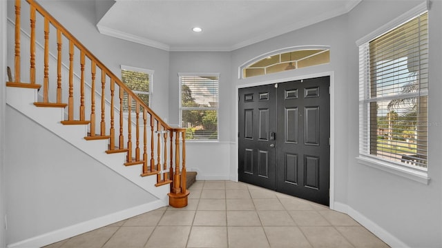 tiled foyer entrance featuring crown molding