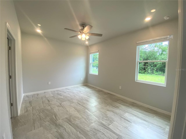 spare room featuring ceiling fan and plenty of natural light