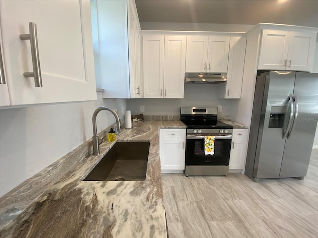 kitchen featuring stone counters, appliances with stainless steel finishes, sink, light wood-type flooring, and white cabinets