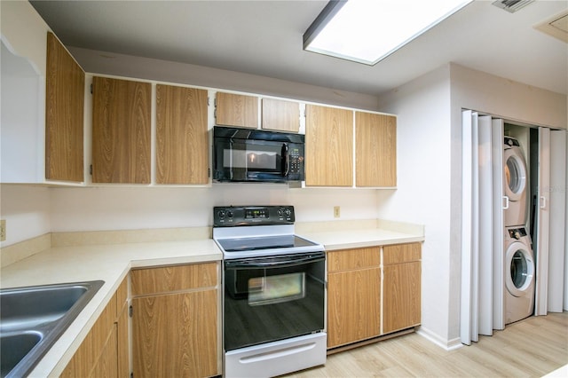 kitchen with stacked washer and clothes dryer, electric range oven, sink, and light hardwood / wood-style flooring