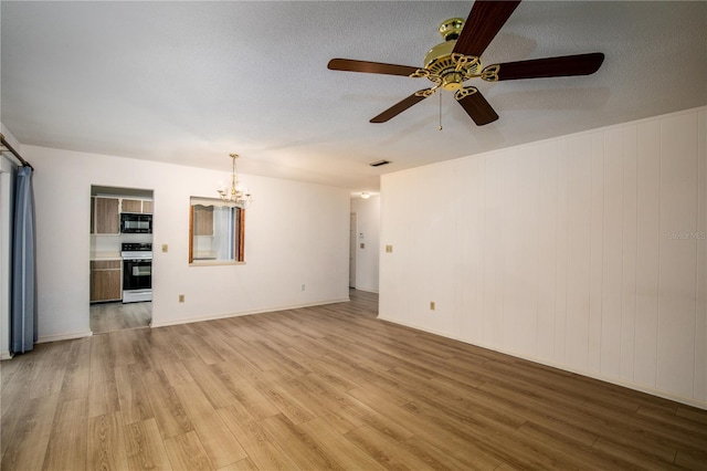 unfurnished living room featuring hardwood / wood-style flooring, ceiling fan with notable chandelier, and a textured ceiling