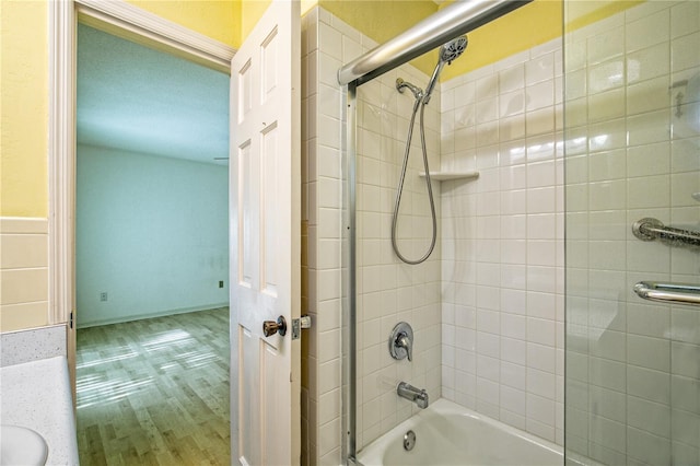 bathroom with vanity, tiled shower / bath combo, and wood-type flooring