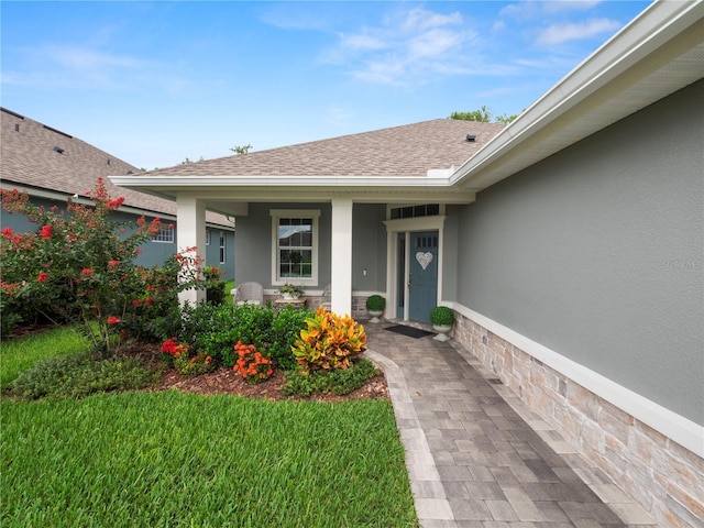 view of exterior entry with a yard