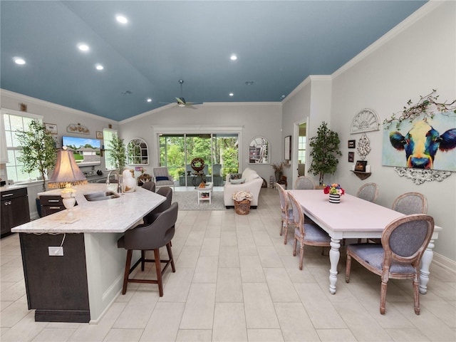 dining space featuring ceiling fan, vaulted ceiling, sink, and ornamental molding