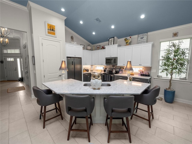 kitchen featuring a breakfast bar area, appliances with stainless steel finishes, white cabinets, and a spacious island