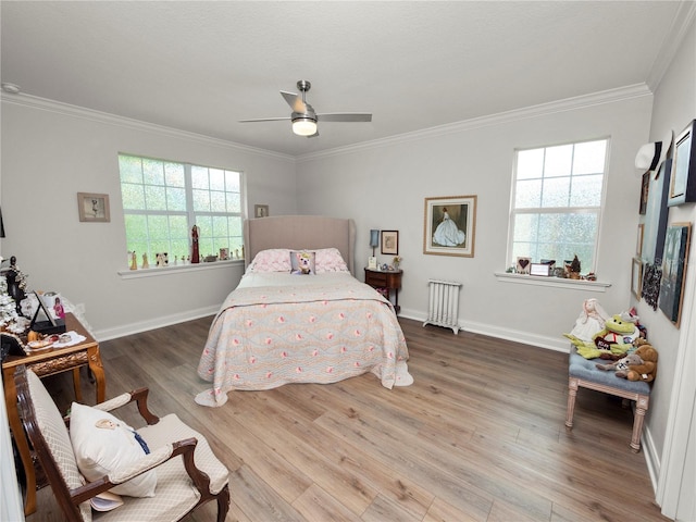 bedroom featuring ceiling fan, hardwood / wood-style flooring, and crown molding