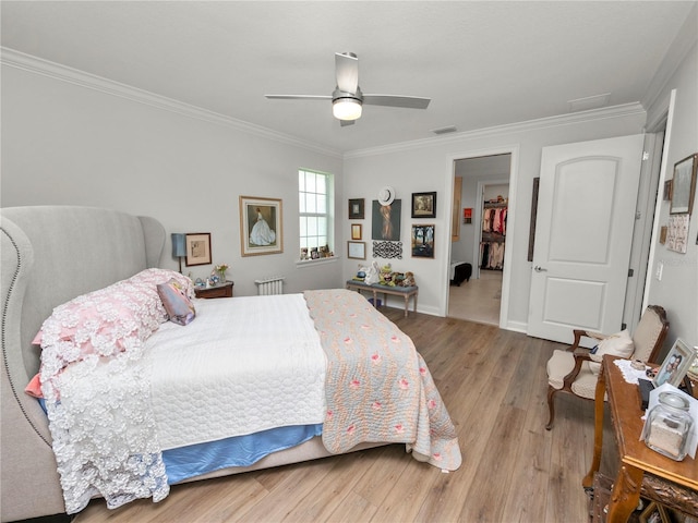 bedroom with ceiling fan, ornamental molding, and light hardwood / wood-style flooring