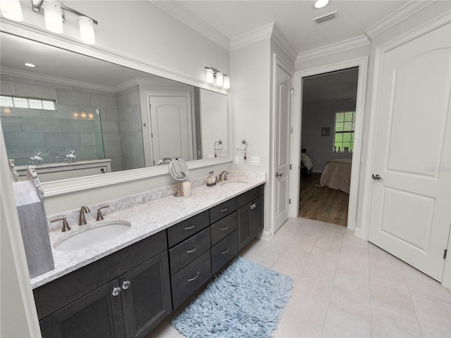 bathroom with crown molding, tile patterned floors, vanity, and a tile shower