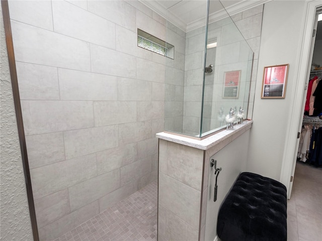 bathroom featuring ornamental molding and tiled shower