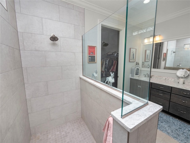 bathroom featuring vanity, crown molding, and a tile shower