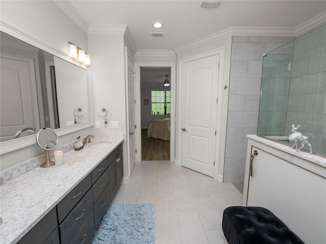 bathroom with tiled shower, vanity, crown molding, and tile patterned flooring