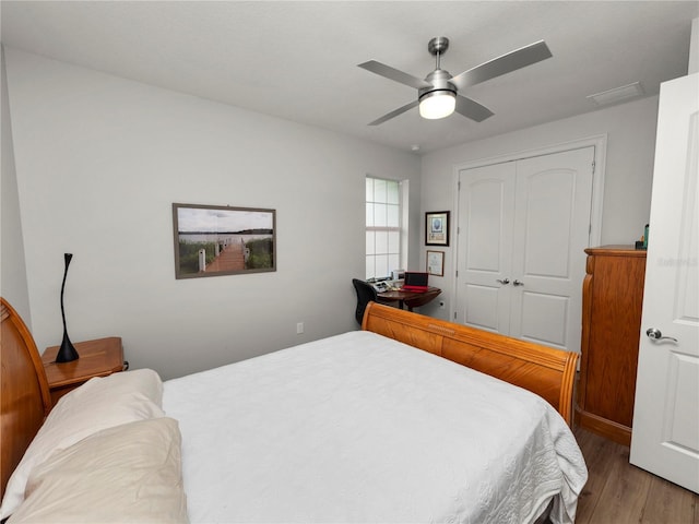 bedroom with ceiling fan, a closet, and light hardwood / wood-style floors