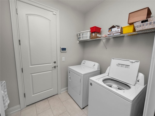 washroom with light tile patterned floors and washer and dryer