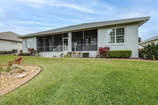 rear view of property featuring central AC, a yard, and a sunroom