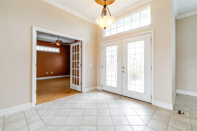 tiled entryway featuring french doors, ornamental molding, and a wealth of natural light