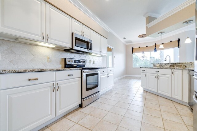 kitchen featuring light stone counters, crown molding, appliances with stainless steel finishes, pendant lighting, and white cabinets