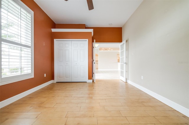 unfurnished bedroom with ceiling fan and a closet