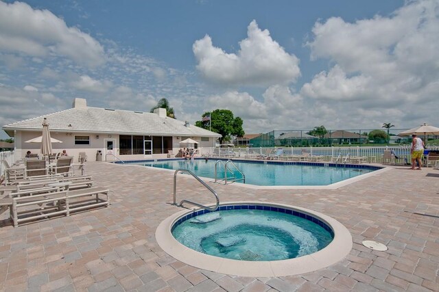 view of swimming pool with a community hot tub and a patio area