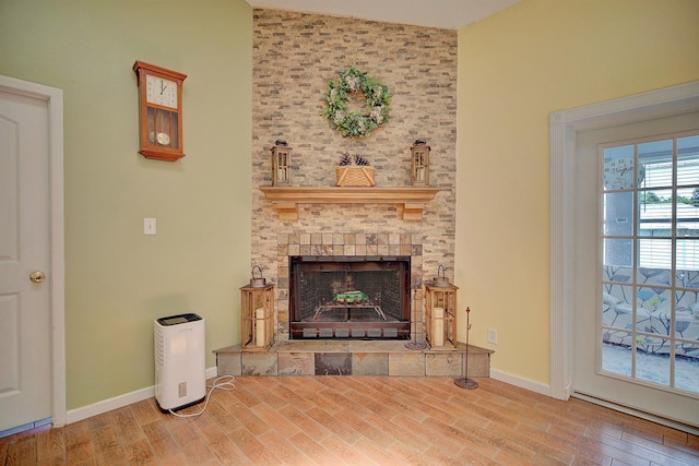 living room featuring lofted ceiling, wood-type flooring, and a large fireplace