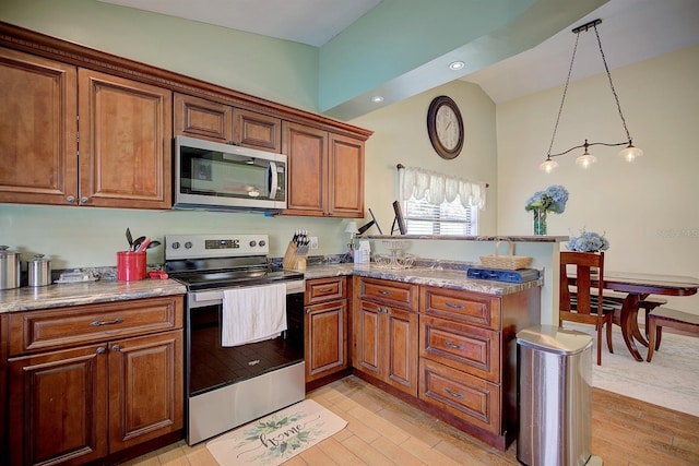 kitchen with appliances with stainless steel finishes, light stone countertops, light hardwood / wood-style flooring, and decorative light fixtures