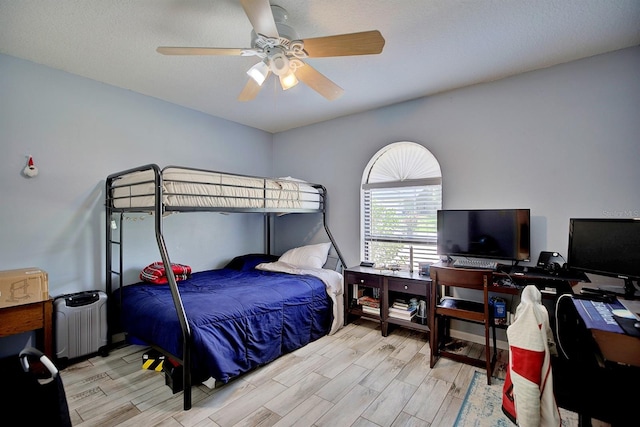 bedroom with radiator heating unit, light hardwood / wood-style flooring, and ceiling fan