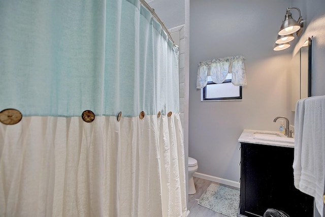 bathroom with vanity, toilet, and hardwood / wood-style floors