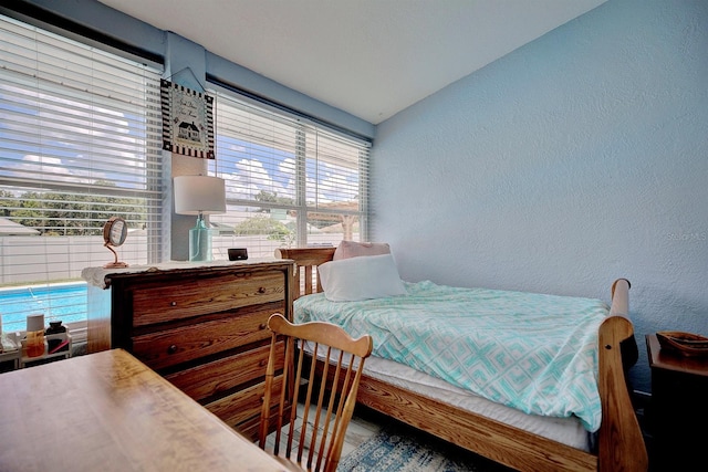 bedroom with multiple windows and lofted ceiling