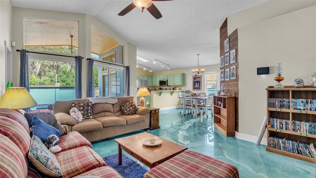 living room featuring ceiling fan with notable chandelier, a textured ceiling, vaulted ceiling, and a healthy amount of sunlight