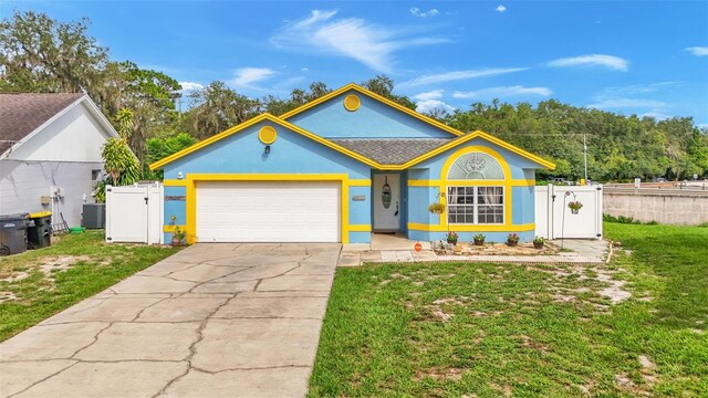 ranch-style home featuring a garage, central AC, and a front lawn