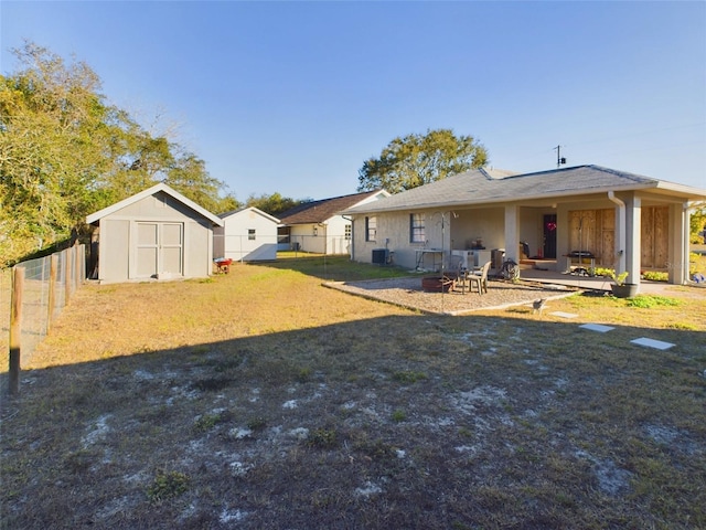 view of yard with a storage shed, a patio area, central air condition unit, and a fire pit