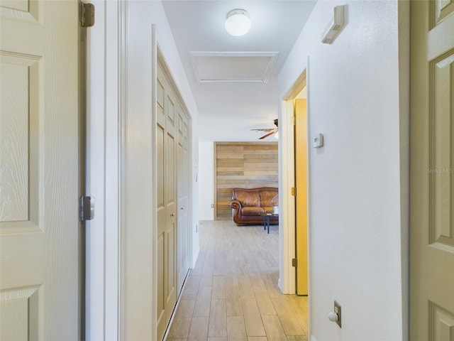 hallway with wood walls and light wood-type flooring