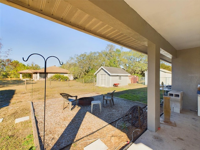 view of patio / terrace featuring a storage shed and an outdoor fire pit