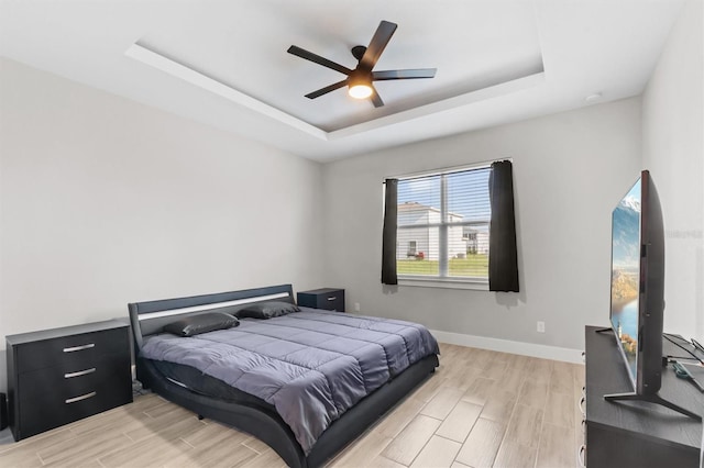 bedroom featuring a raised ceiling and ceiling fan