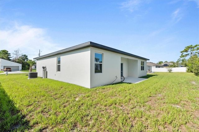 view of side of home featuring central AC, a yard, and a patio area