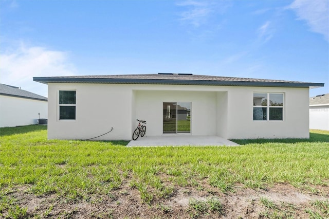 back of property with cooling unit, a patio area, and a lawn