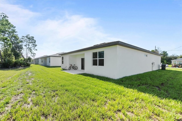 back of property featuring a yard and a patio area