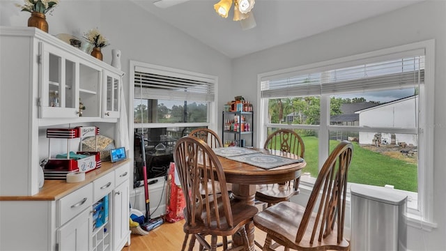 dining area with vaulted ceiling, light wood-type flooring, and ceiling fan