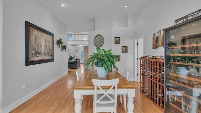 dining room featuring high vaulted ceiling and light wood-type flooring