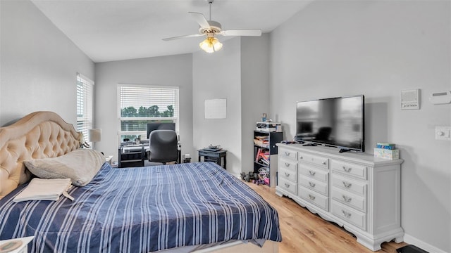 bedroom with ceiling fan, lofted ceiling, and light hardwood / wood-style floors