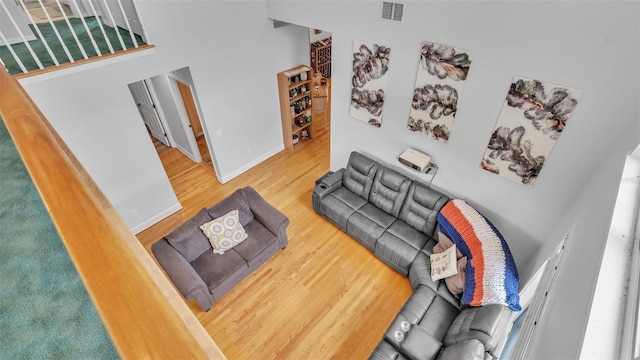 living room featuring wood-type flooring and a towering ceiling