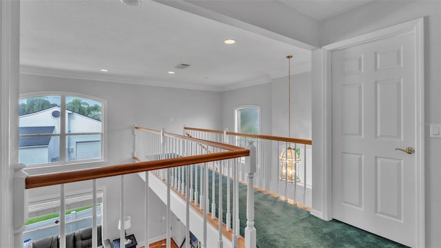 hallway featuring ornamental molding, carpet flooring, and plenty of natural light