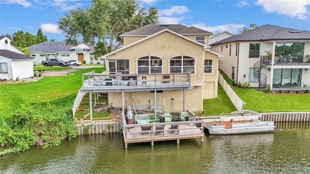 back of property with a water view and a lawn