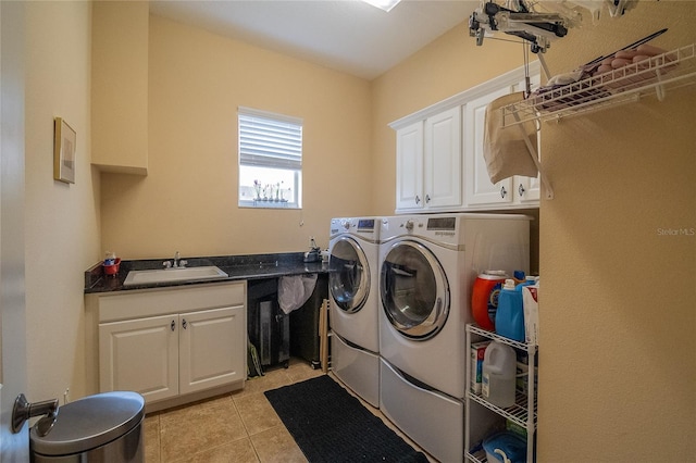 clothes washing area featuring a sink, cabinet space, separate washer and dryer, and light tile patterned flooring