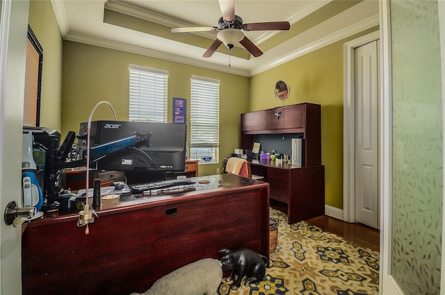 office space featuring a tray ceiling, wood finished floors, a ceiling fan, and ornamental molding