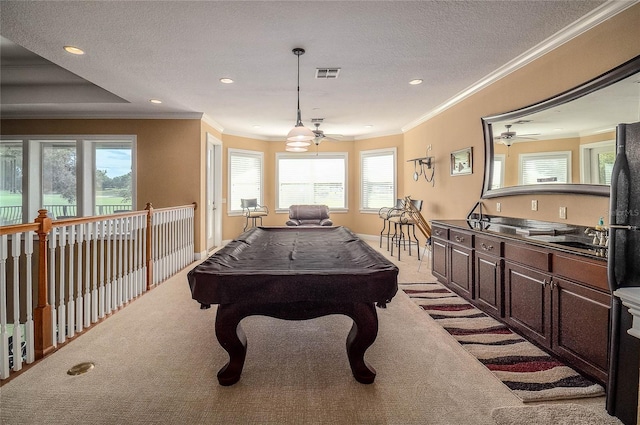 game room with carpet flooring, a ceiling fan, visible vents, and ornamental molding