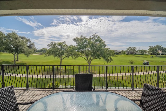 view of patio with view of golf course and a balcony