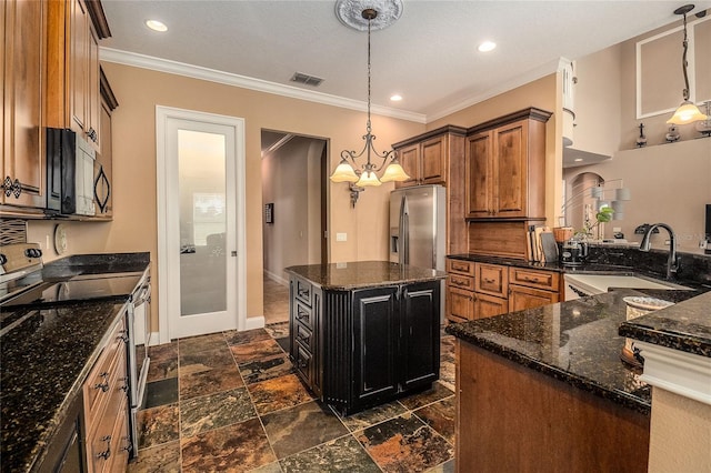 kitchen with visible vents, a sink, appliances with stainless steel finishes, crown molding, and brown cabinets