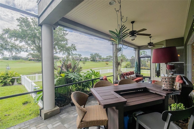 sunroom featuring ceiling fan