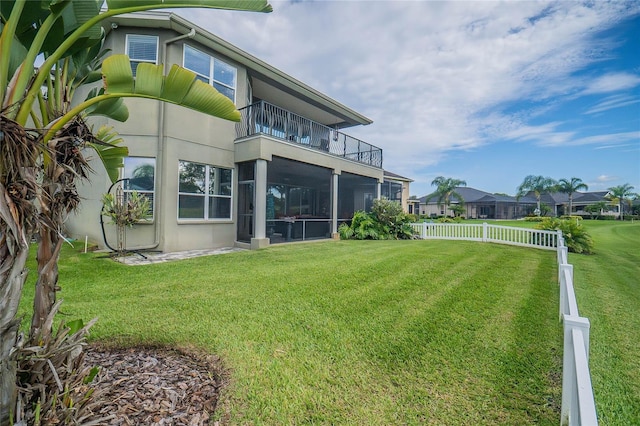 view of yard featuring a balcony and fence
