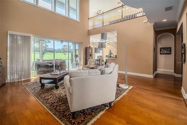 living room with visible vents, a healthy amount of sunlight, baseboards, and wood finished floors